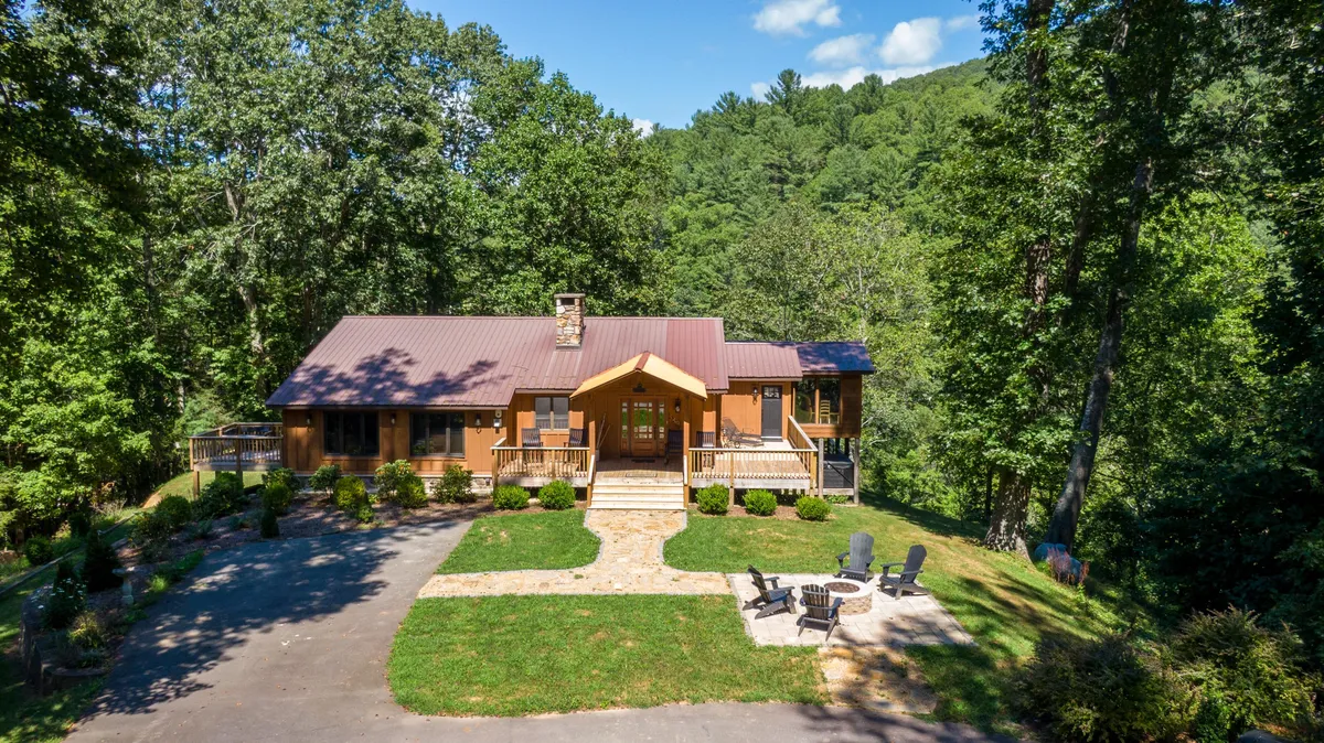 This image captures the exterior main entrance of the property with an inviting outdoor seating area and a landscaped pathway leading to the home. The seating is arranged around a firepit, perfect for group gatherings. The scene is welcoming, suggesting a place where friends and family can come together, especially for evening activities like stargazing or sharing stories by the fire.